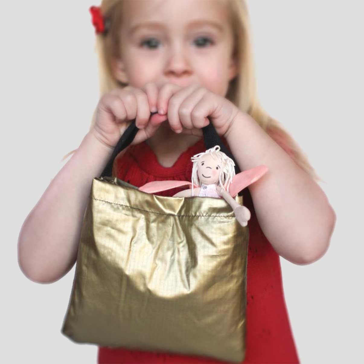 Close up of folded Gold Metallic bag folded and little girl